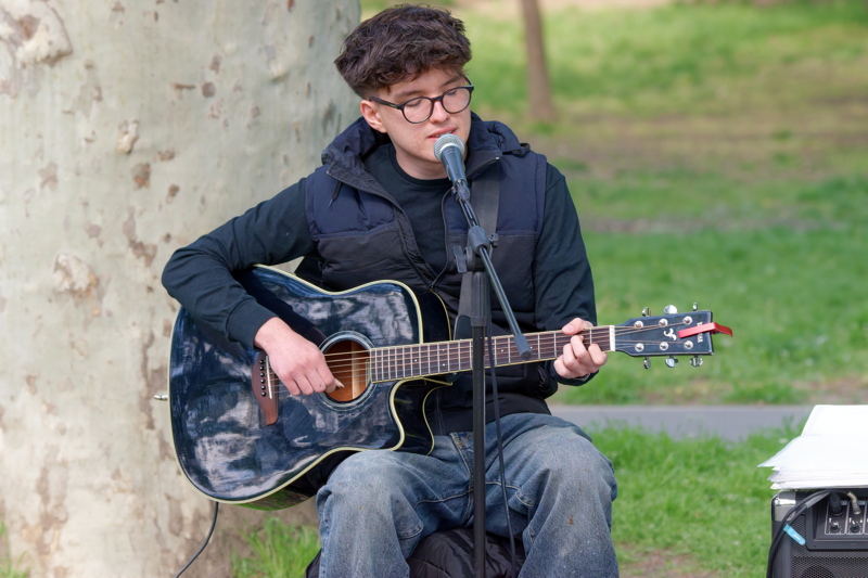 Boy playing acoustic guitar in the park